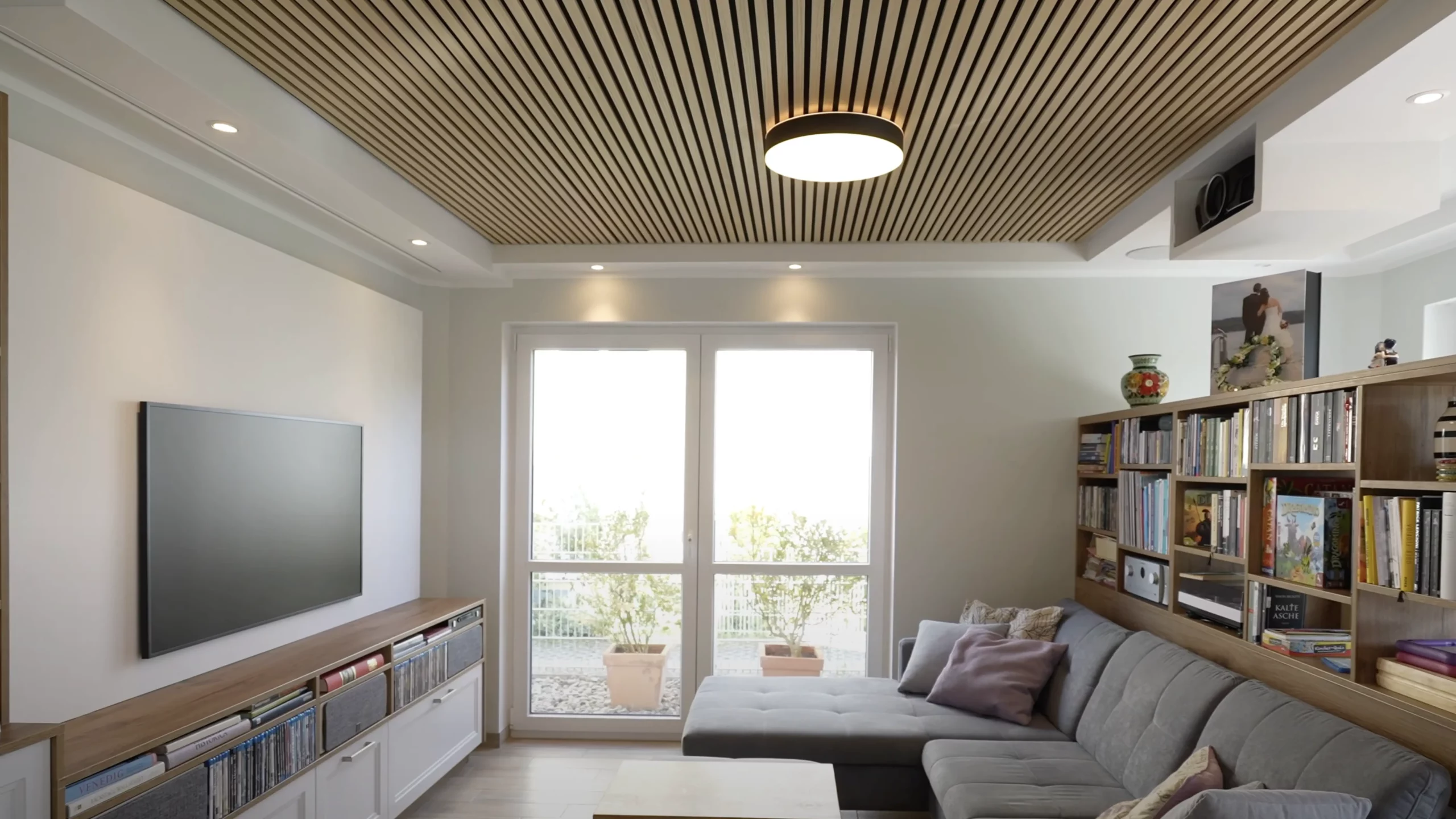 Modernes Wohnzimmer im mit Holzlamellen Decke mit stilvoll integriertem Heimkino. In diesem Wohnzimmer gibt es sowohl eine Fernseher- als auch eine Beamer-Leinwand Lösung.
