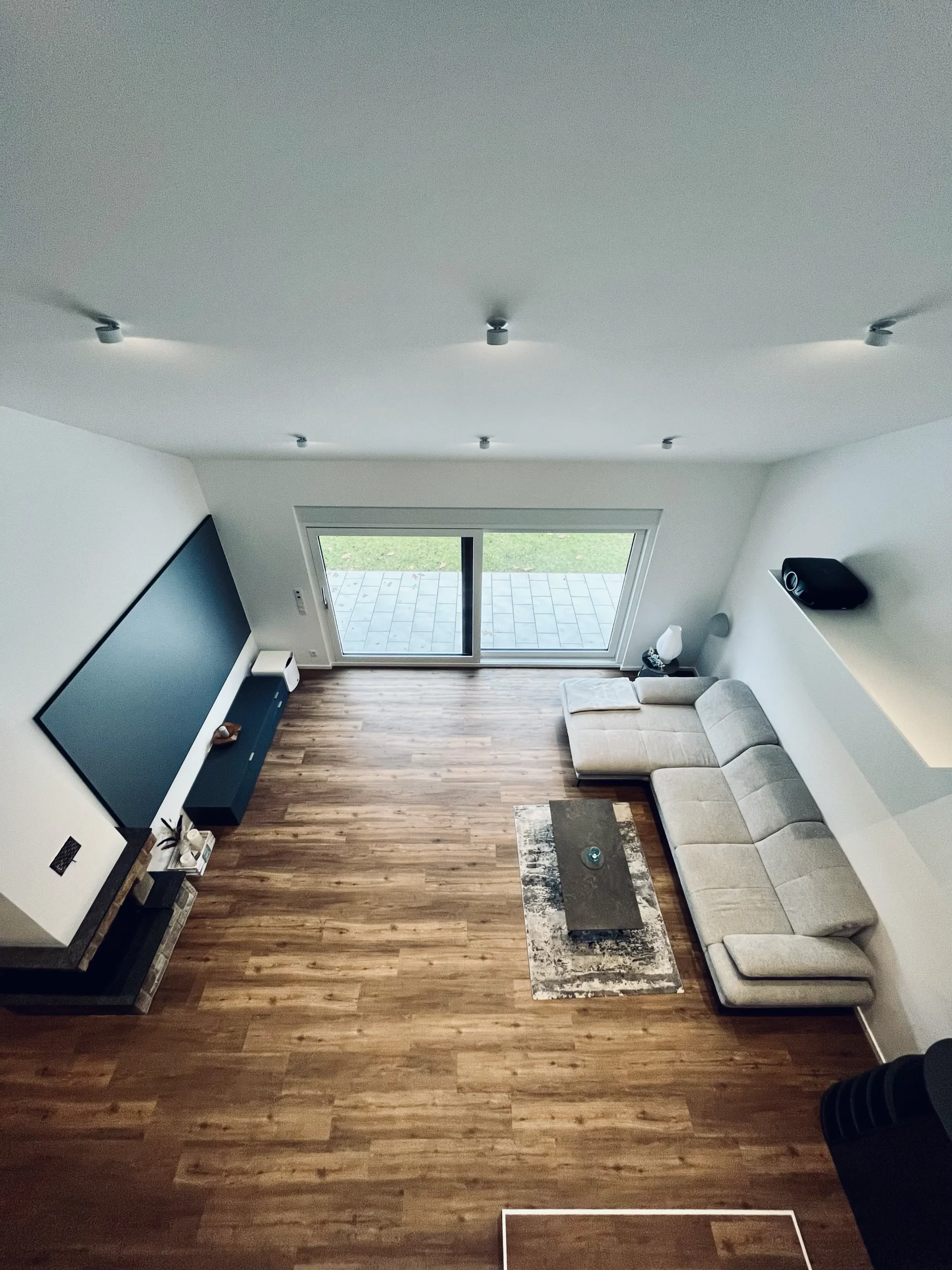 Heimkino im hellen Wohnzimmer mit ausgefeilten Lösungen für eine elegante Beamermontage, gebaut vom AVITECT Studio Rhein-Main.