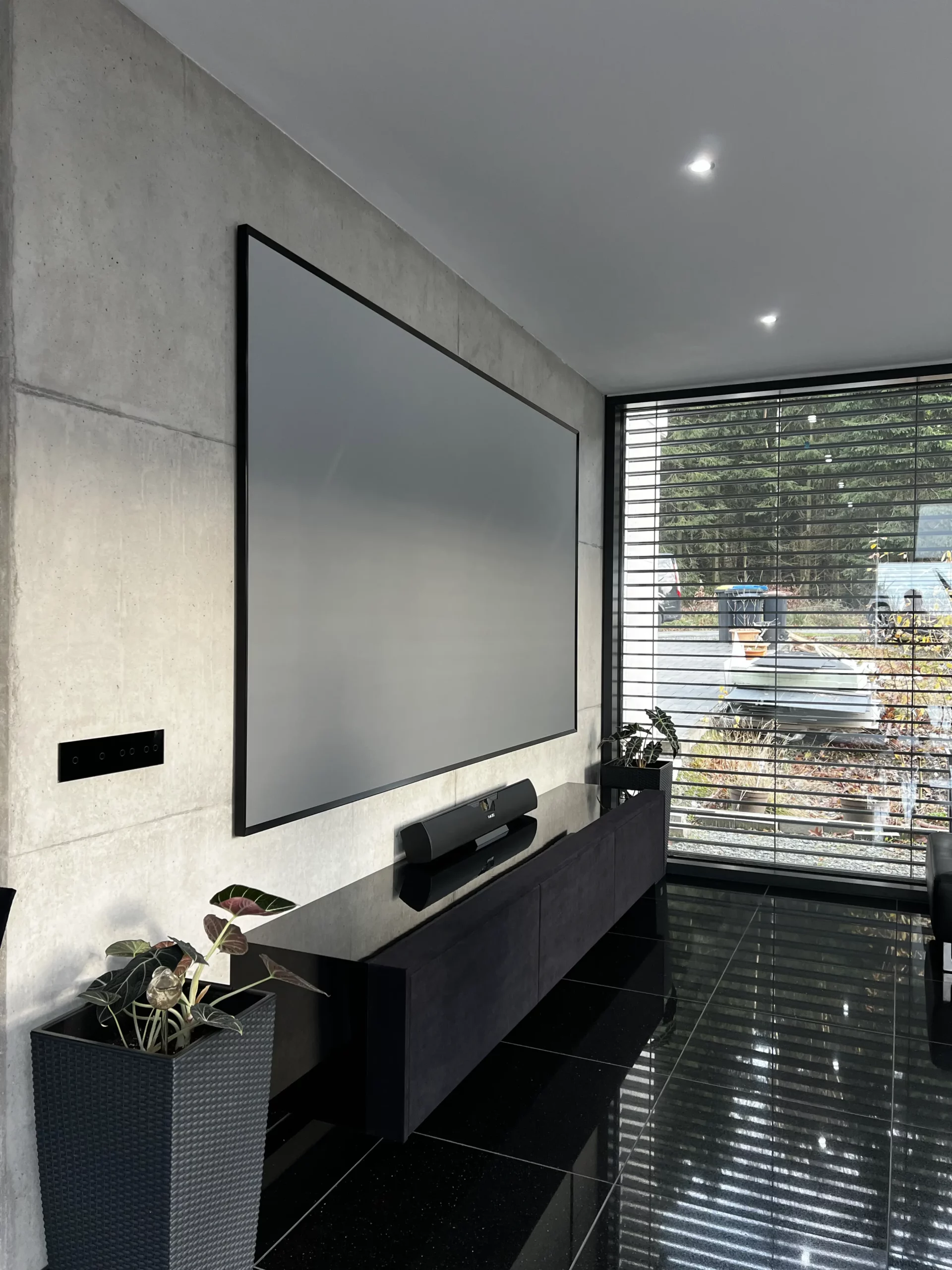 Schwarzes maßgefertigtes Laser TV in hyper modernen Wohnzimmer.