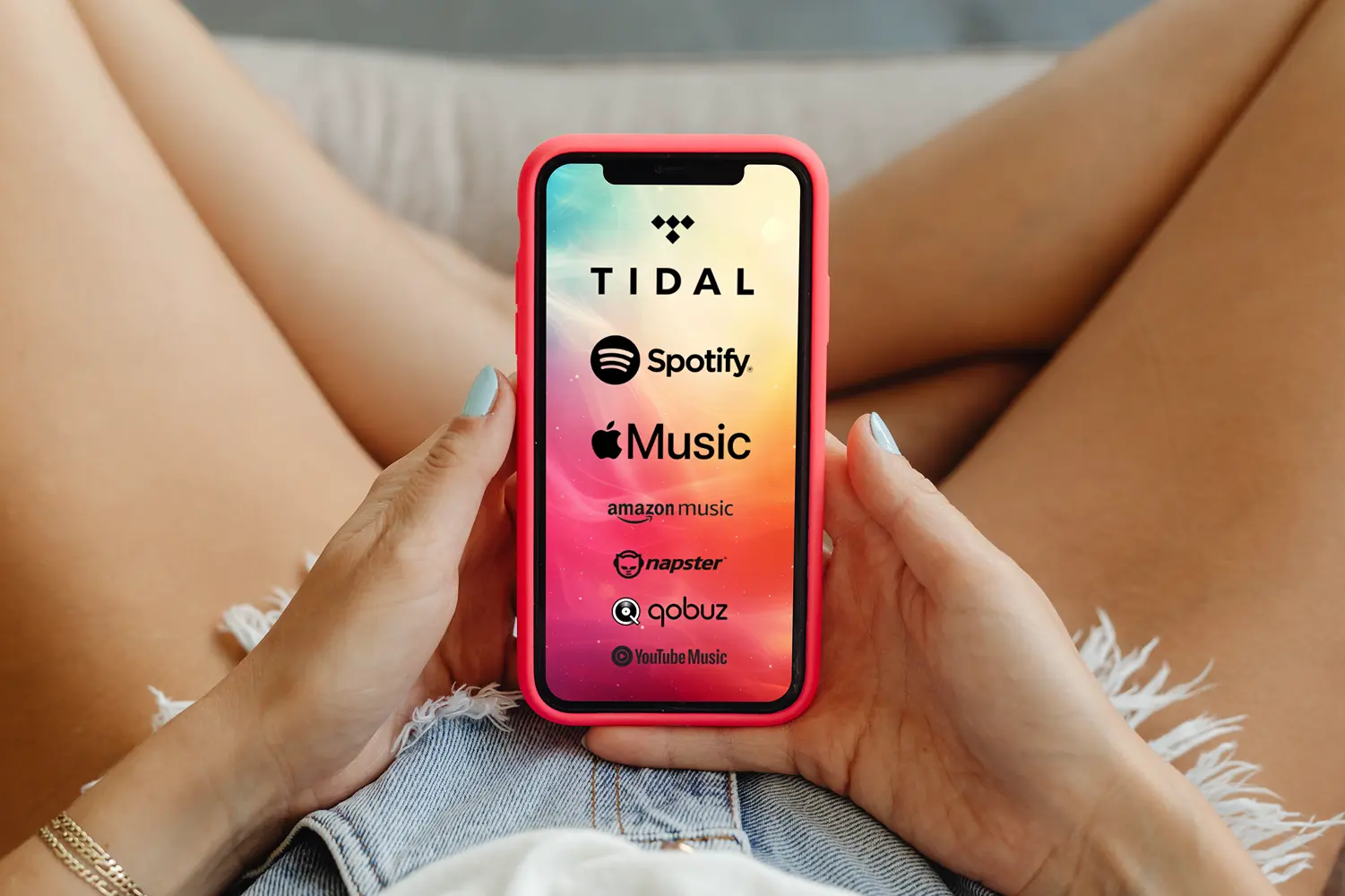 Eine Frau hält ein Handy, auf dem die Logos der wichtigsten Streaming Anbieter zu sehen sind: Tidal, Spotify, Apple Music, Amazon music, Napster, qobuz und YouTube Music.