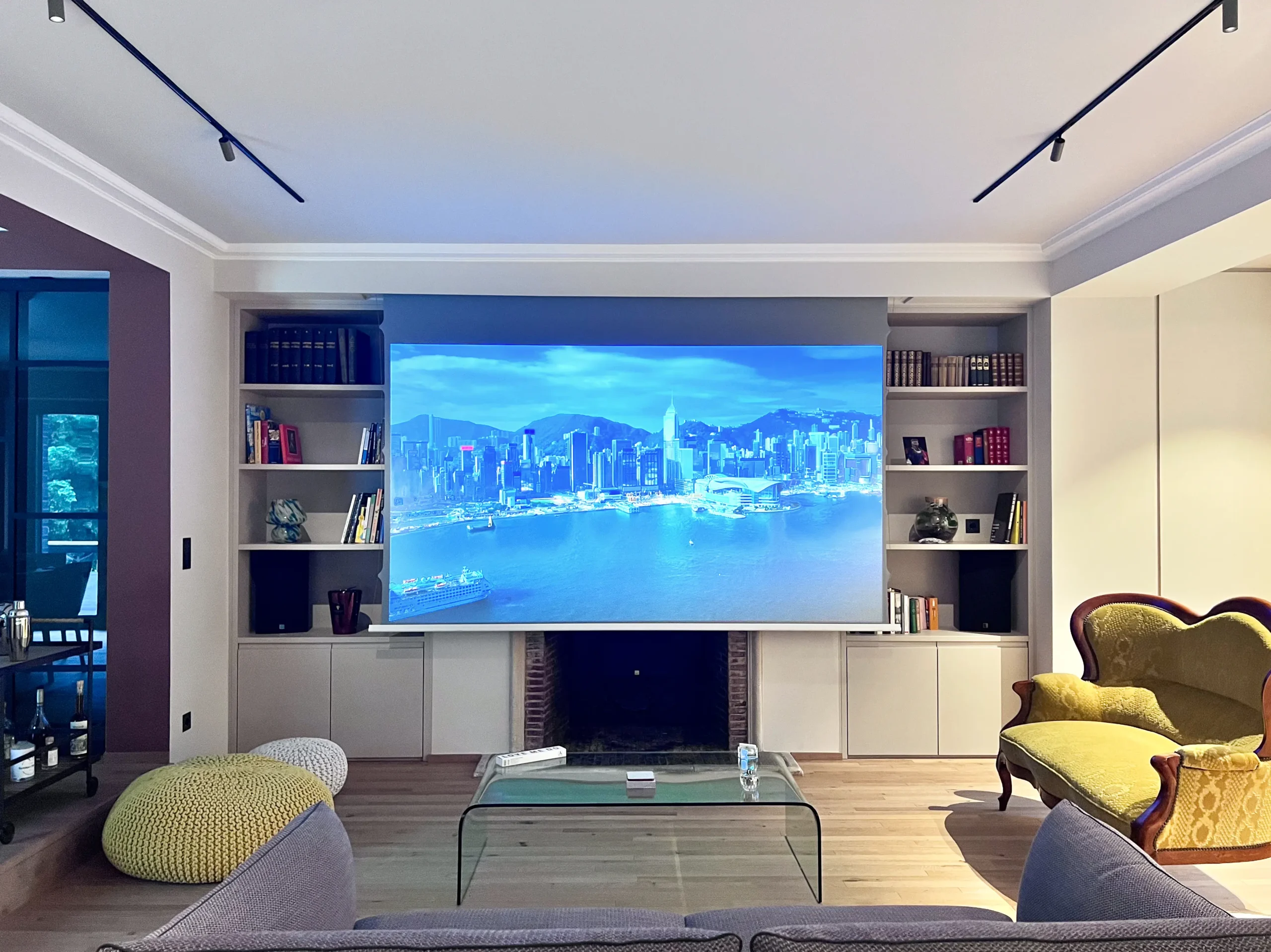 Heimkino in modernem Wohnzimmer, das komplett kernsaniert wurde. Zu sehen ist die ausgefahren Screenline Radiance Bright InCeiling Edge Free Tension Leinwand auf die gerade ein Bild projiziert wird.