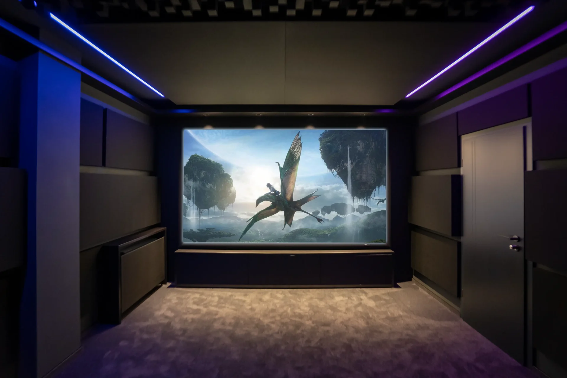 Frontansicht eines Heimkinos mit Projektion auf akustisch transparenter Leinwand, umgeben von LED-Lichtlinien, Akustikmodulen und flächenbündiger Tür – Black Cinema Design vom AVITECT Studio Bochum