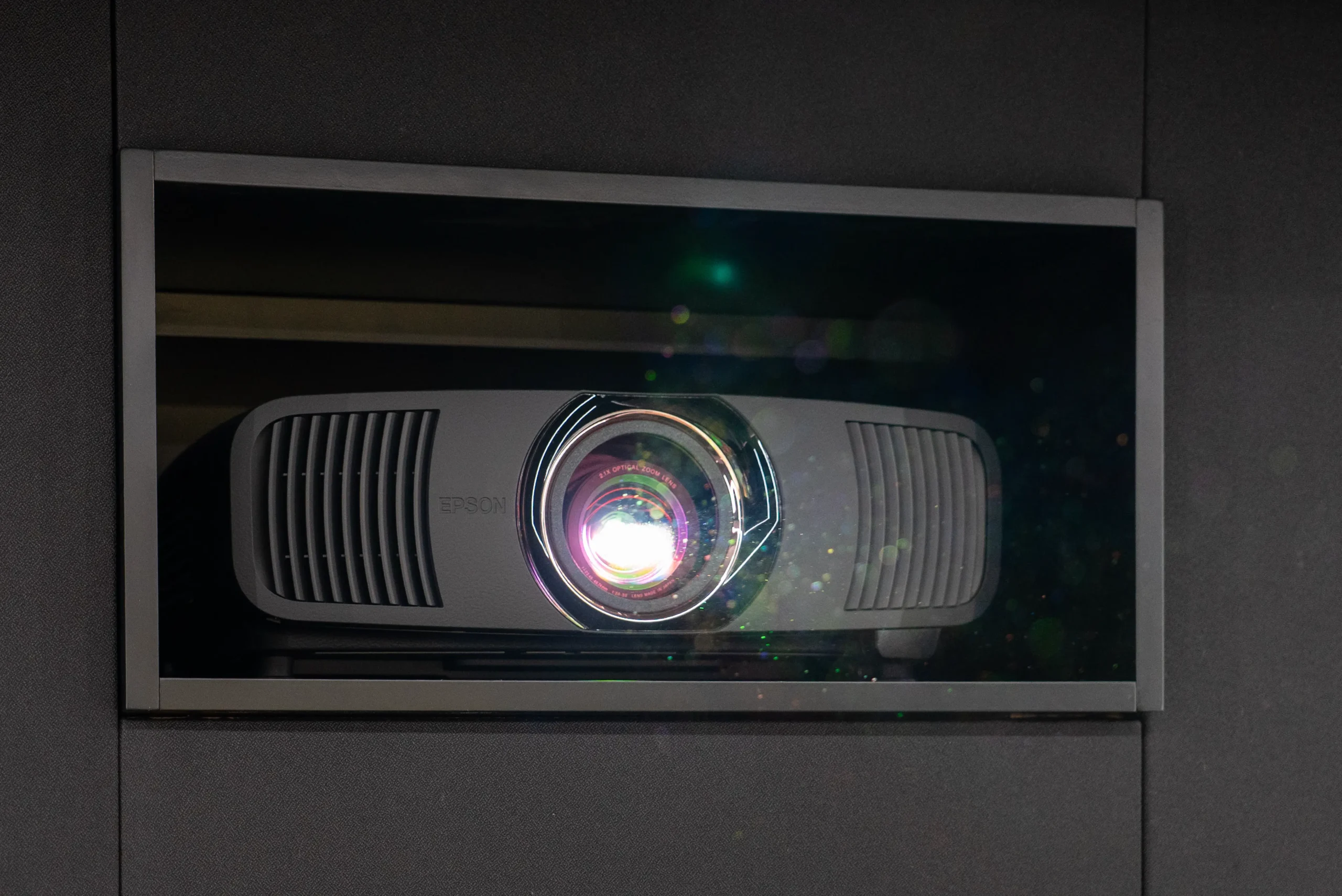 Epson Beamer mit eingeschaltetem Objektiv und AVITECT MasterTuning im Black Cinema Heimkino – Studio Bochum.