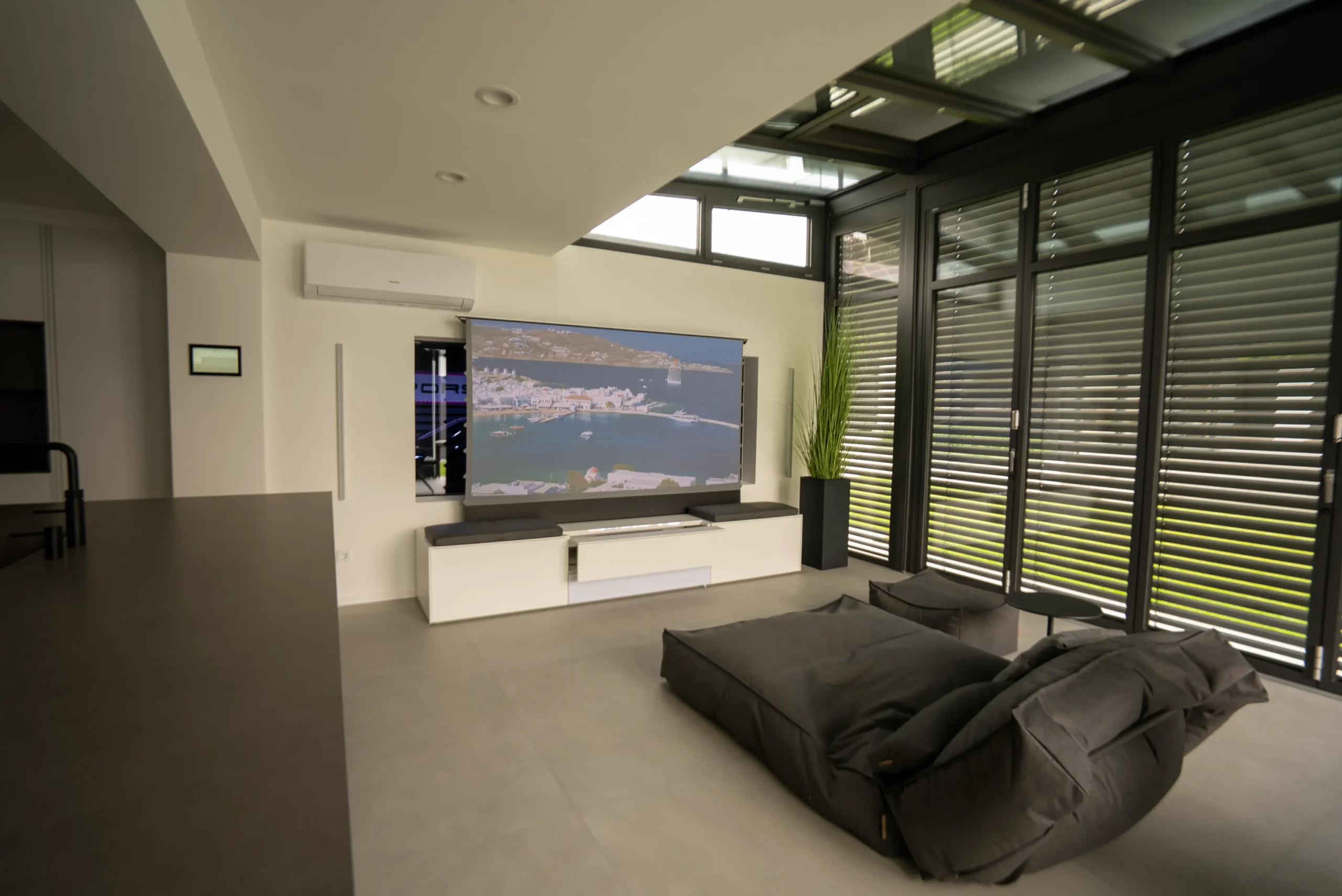 LaserTV-Lösung im Wohnbereich mit Floor-Up Leinwand, eleganter Möbelintegration – geplant vom AVITECT Studio Bochum.