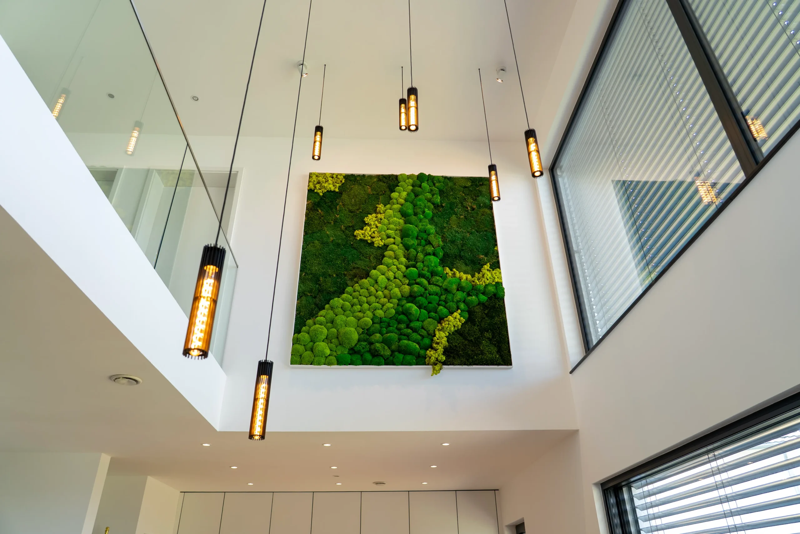 Mooswand in lichtdurchflutetem Atrium mit moderner Hängeleuchte, AVITECT Studio Rhein-Main
