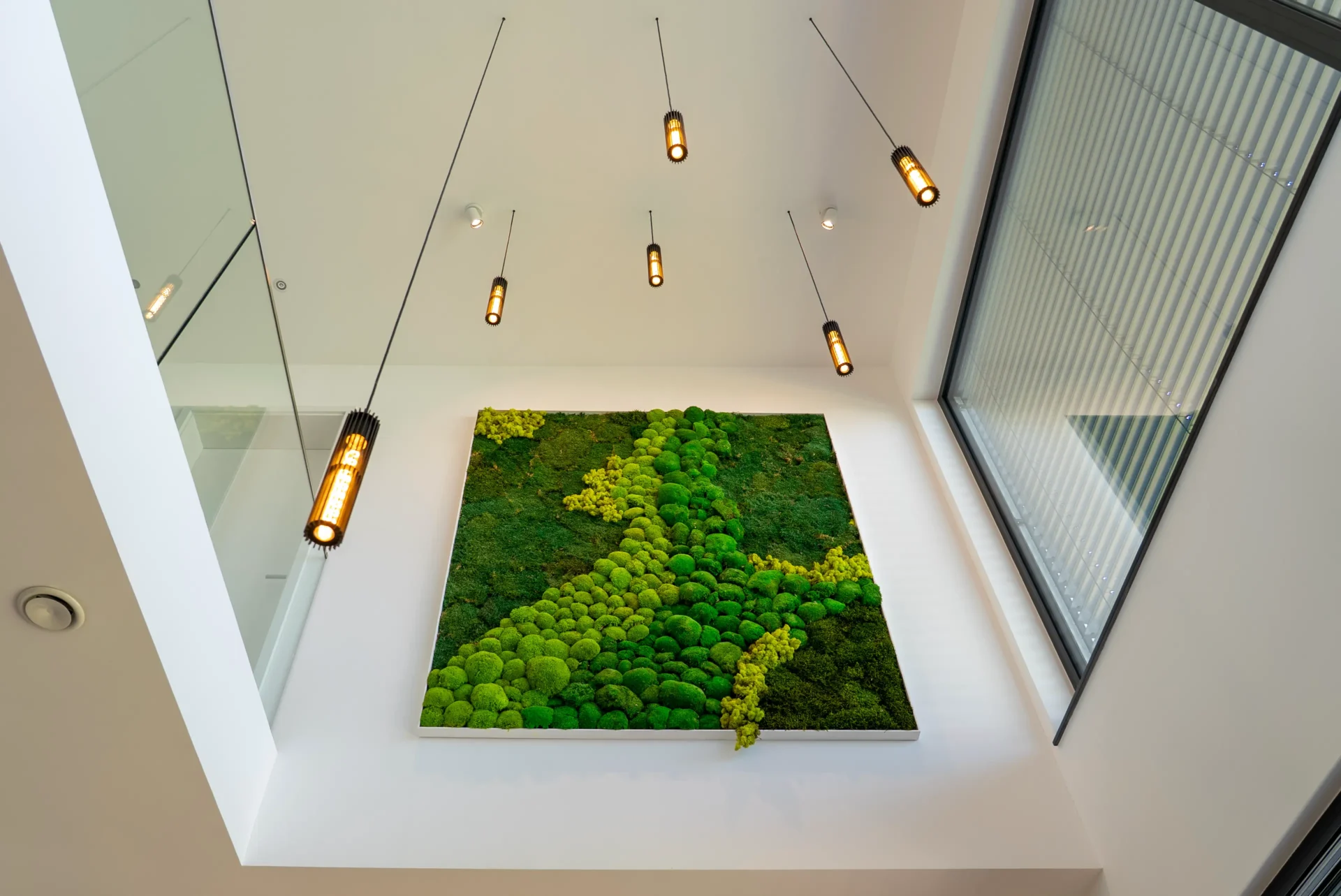 Hohe Mooswand in modernem Atrium mit Glasgeländern und Designerbeleuchtung, AVITECT Studio Rhein-Main
