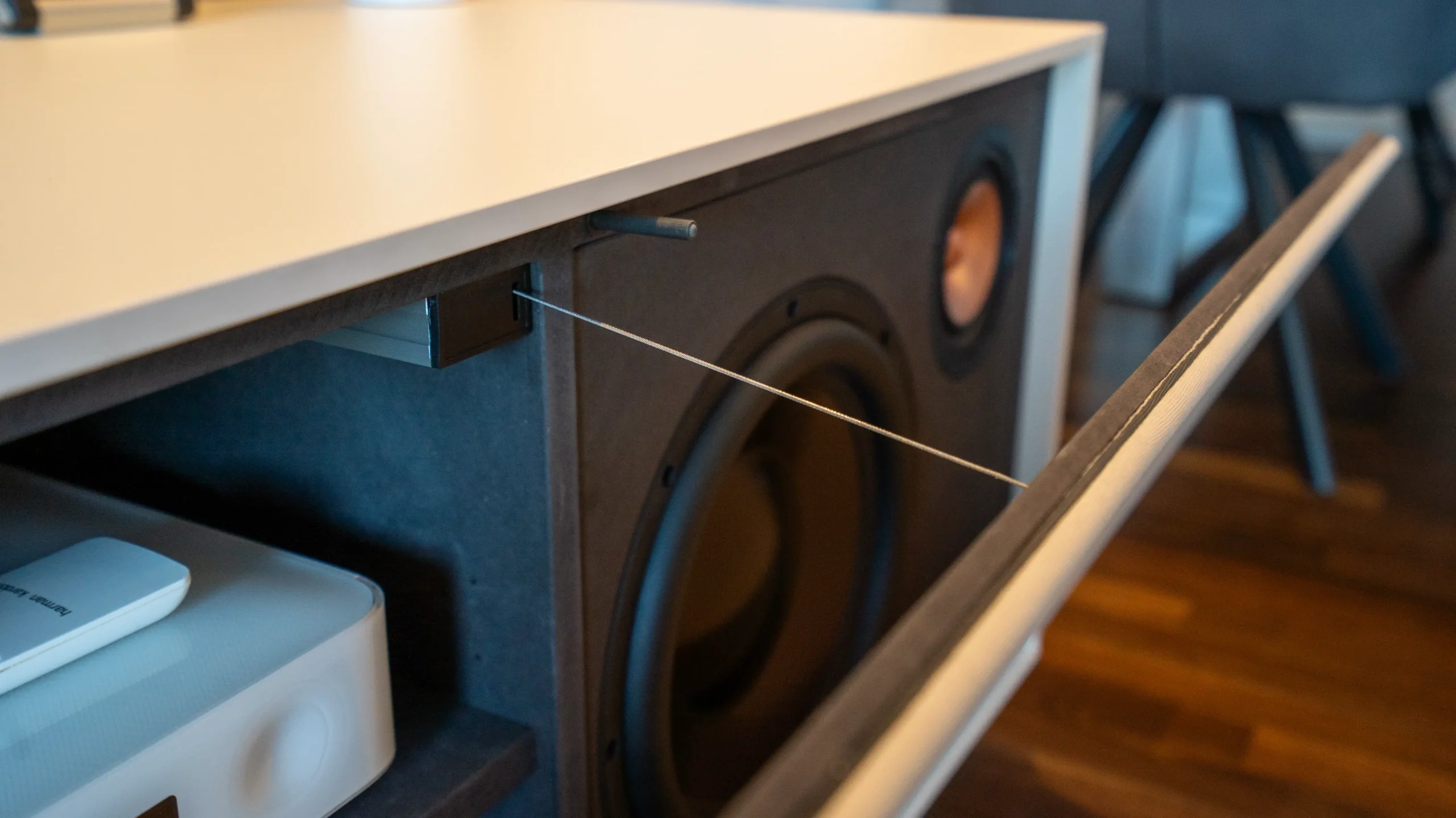 Detailansicht der Möbelkonstruktion vom AVITECT Studio Rhein-Main mit integriertem Subwoofer und akustisch transparenter Abdeckung.