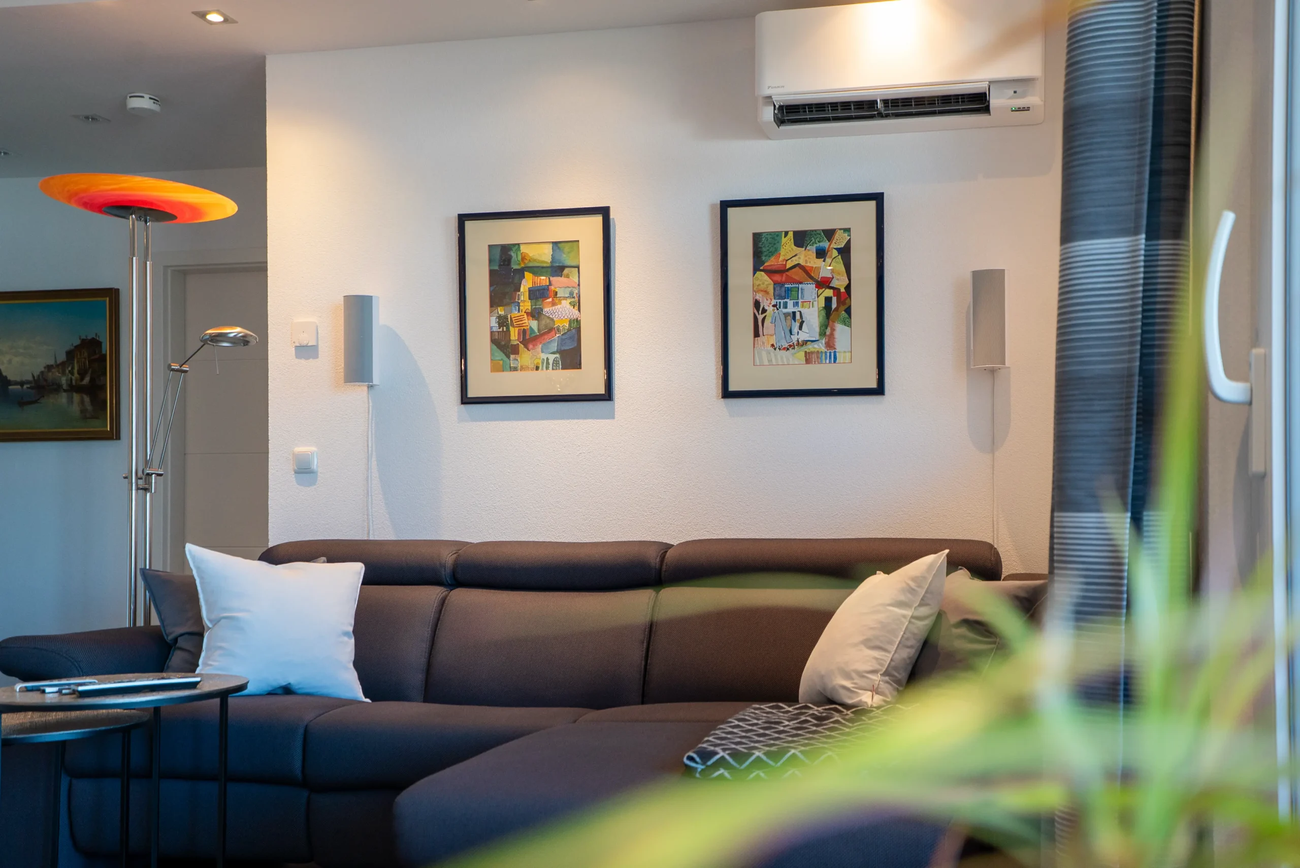 Surround-Lautsprecher an der Wohnzimmerwand, Teil des Heimkino-Systems vom AVITECT Studio Rhein-Main mit Laser TV und Möbelintegration.