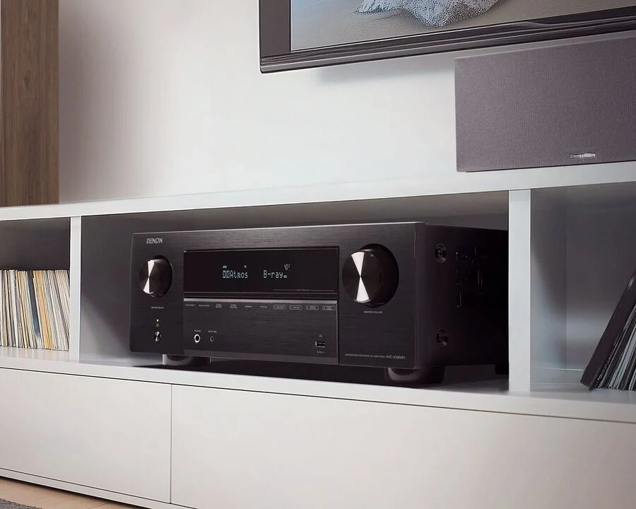 Das Bild zeigt den Denon AVR-X2850H in einem weißen Möbel.