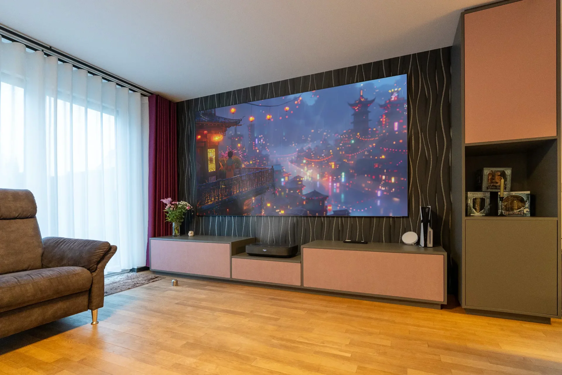 Wohnzimmer-Heimkino in Frankfurt mit farbintensiver Stadtansicht auf der Leinwand – Laser TV, Vorhänge und Lowboard sorgen für beeindruckende Bilder trotz Tageslicht.