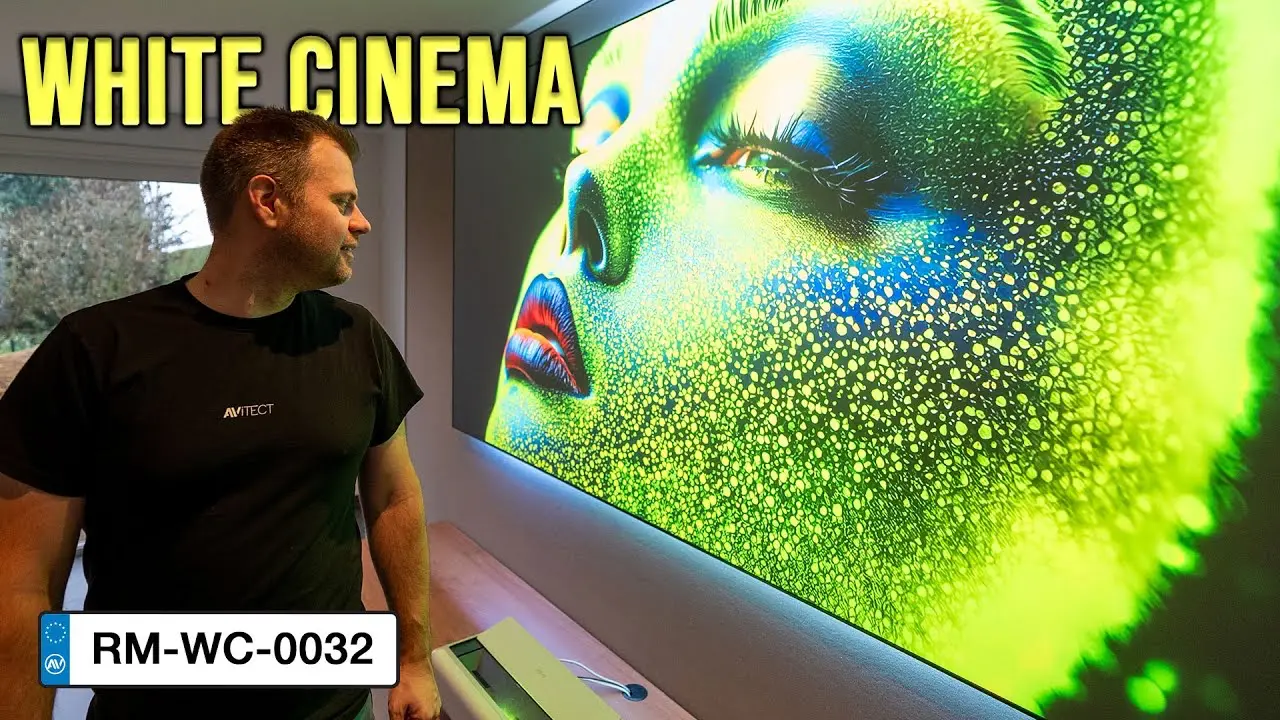 YouTube Thumbnail für eine White Cinema Lösung aus dem AVITECT Studio Rhein-Main. Das Thumbnail zeigt Sebastian Bieger, der sich eine CLR Leinwand ansieht, hinter der ein Ambilight System verbaut ist.