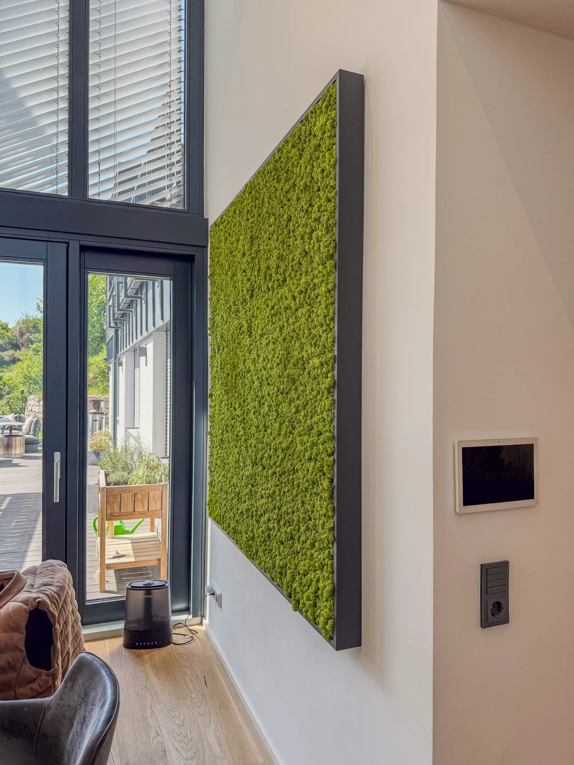 Schallschluckende Mooswand neben Smart-Home-Tablet am Essbereich in der Raumakustik-Maßnahme Rhein-Main.