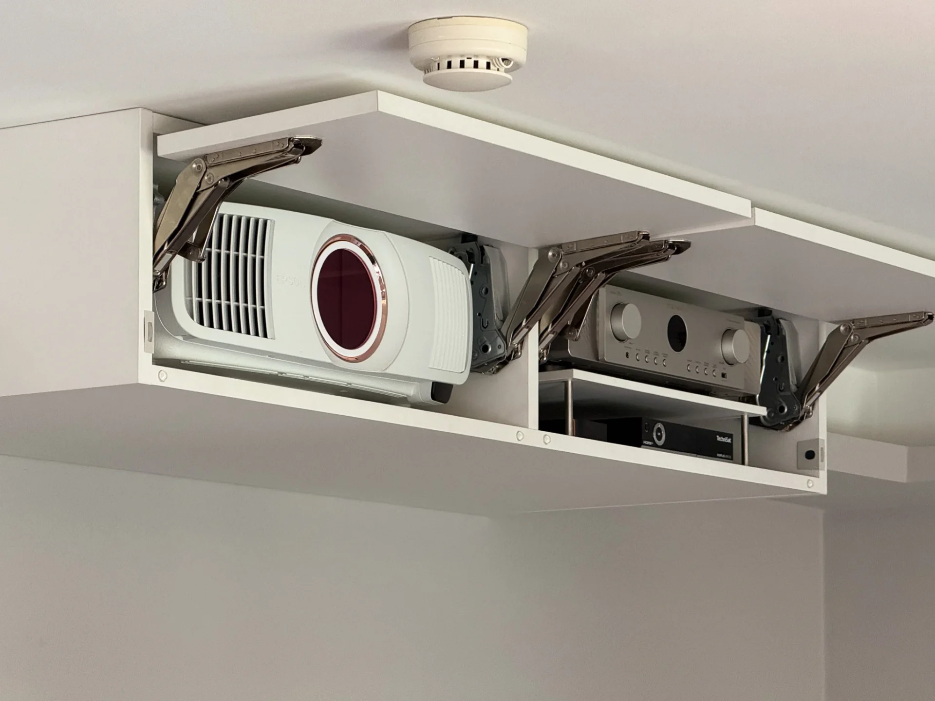 Geöffneter Decken-Beamerkasten mit Epson-Projektor und Marantz AV-Receiver in Klappen-Möbel im Heimkino Rhein-Main.