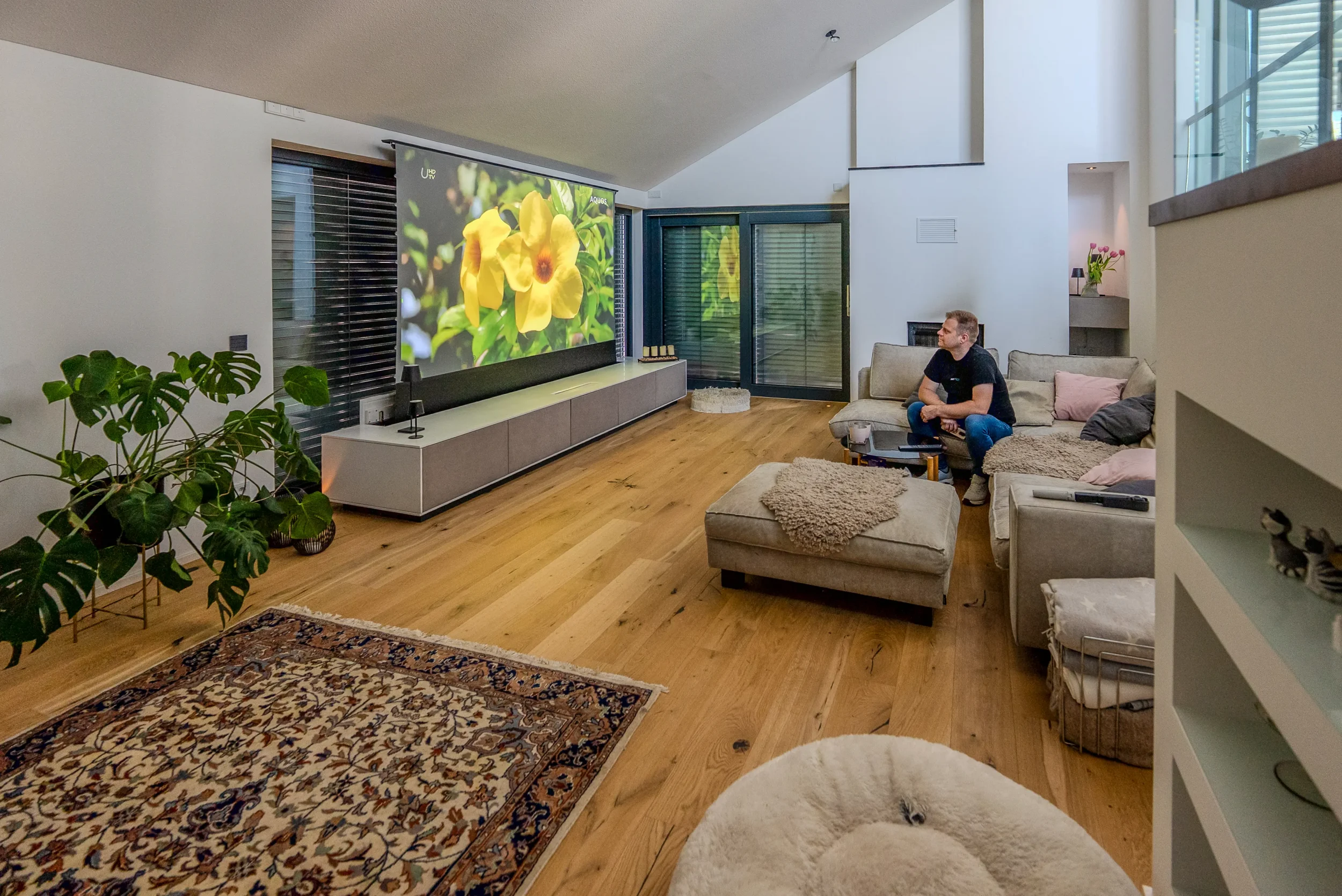 Kinobetrieb mit Blumenmotiv auf der Bodenleinwand, Ecksofa und Orientteppich im Wohnraumkino Rhein-Main.