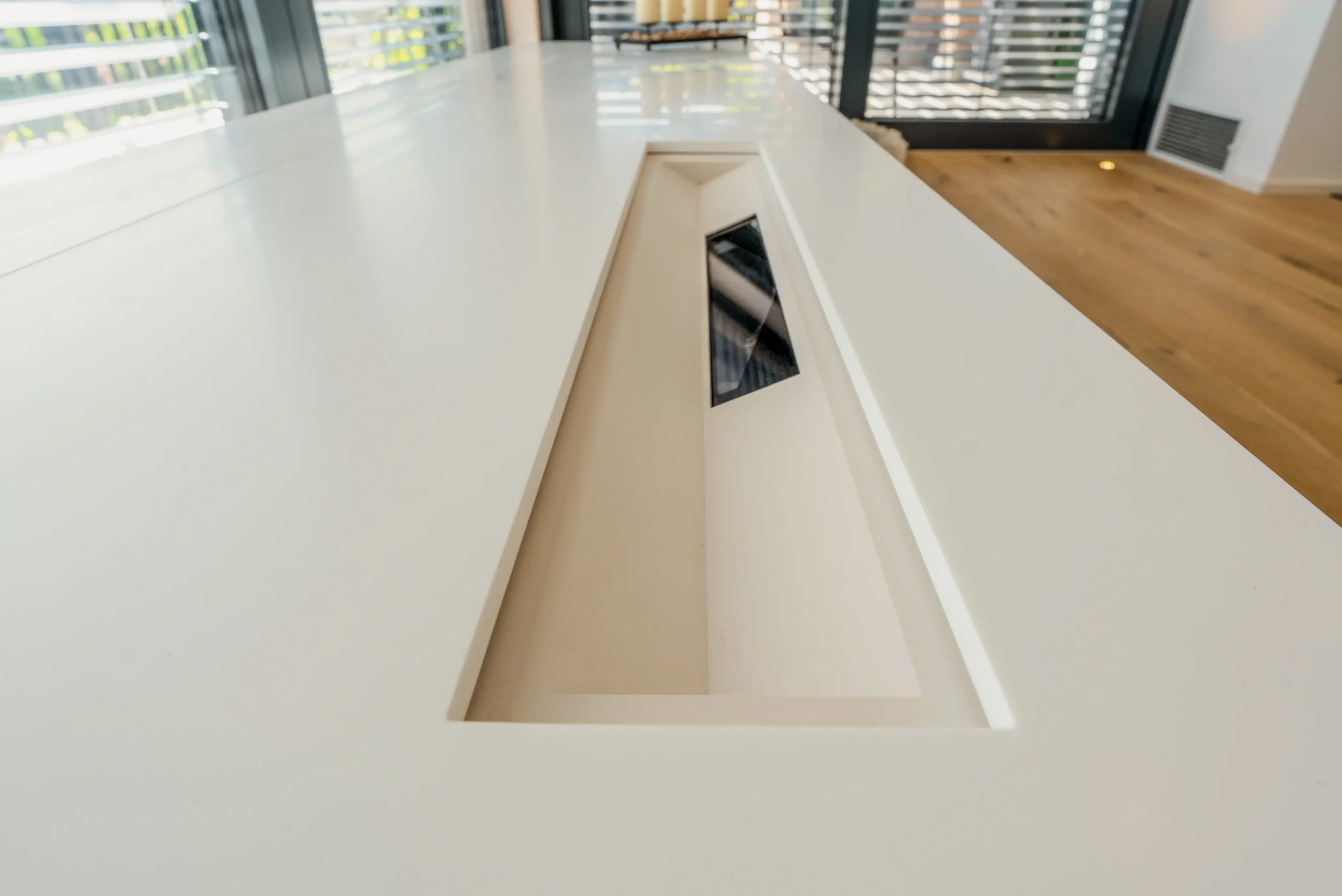 Ausschnitt in der HIMACS-Platte für Laser-TV und Leinwandmechanik im maßgefertigten Lowboard im Wohnraumkino Rhein-Main.
